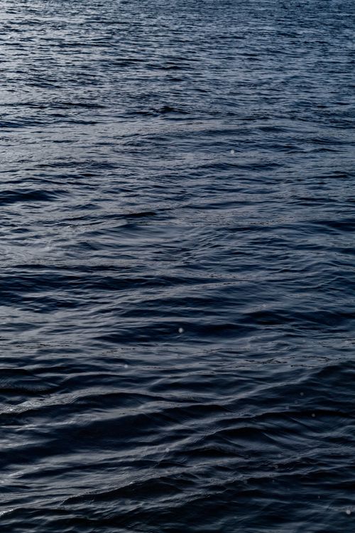 Free A calm ocean surface featuring rippling patterns and subtle textures. Stock Photo