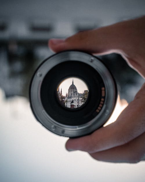 Person Holding Black Camera Lens