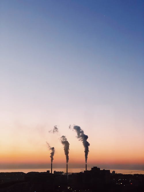 Silhouette of an Industrial Area with Pollution during Sunset