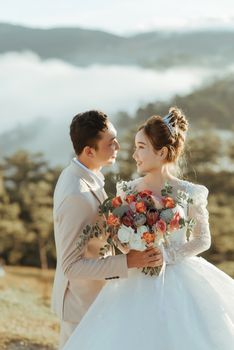 A couple shares a tender moment during their wedding in a picturesque outdoor setting.
