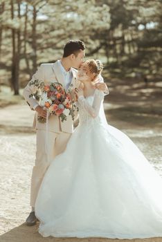 Romantic outdoor wedding scene with a bride and groom in a loving embrace.