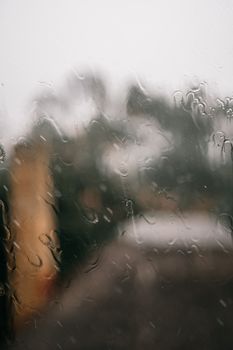 Blurred view through a window with rain droplets creating a natural abstract pattern.