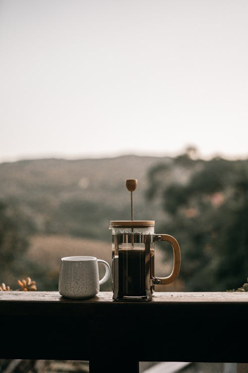 Free A French Press with Coffee on a Wooden Railing Stock Photo