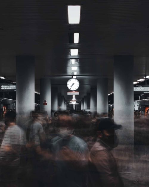 Free Blurry motion in busy metro station corridor with overhead clock, capturing urban rush. Stock Photo