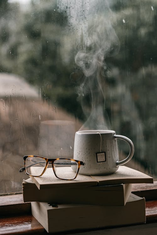 bir bardak çay, cam pencere, dikey atış içeren Ücretsiz stok fotoğraf