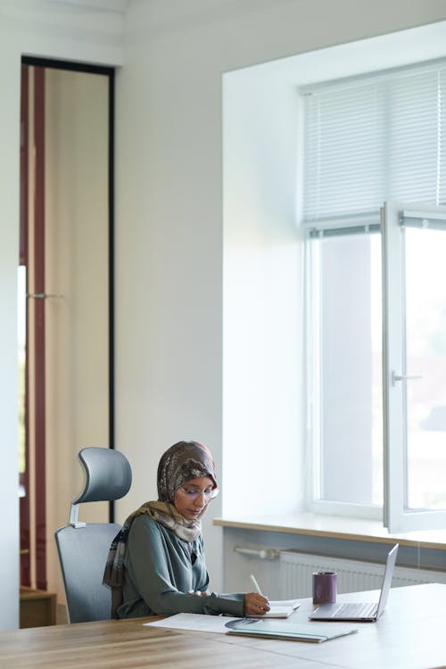 A Woman Writing on a Notebook