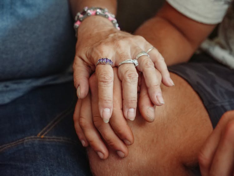 Woman Holding A Man's Hand On His Knee