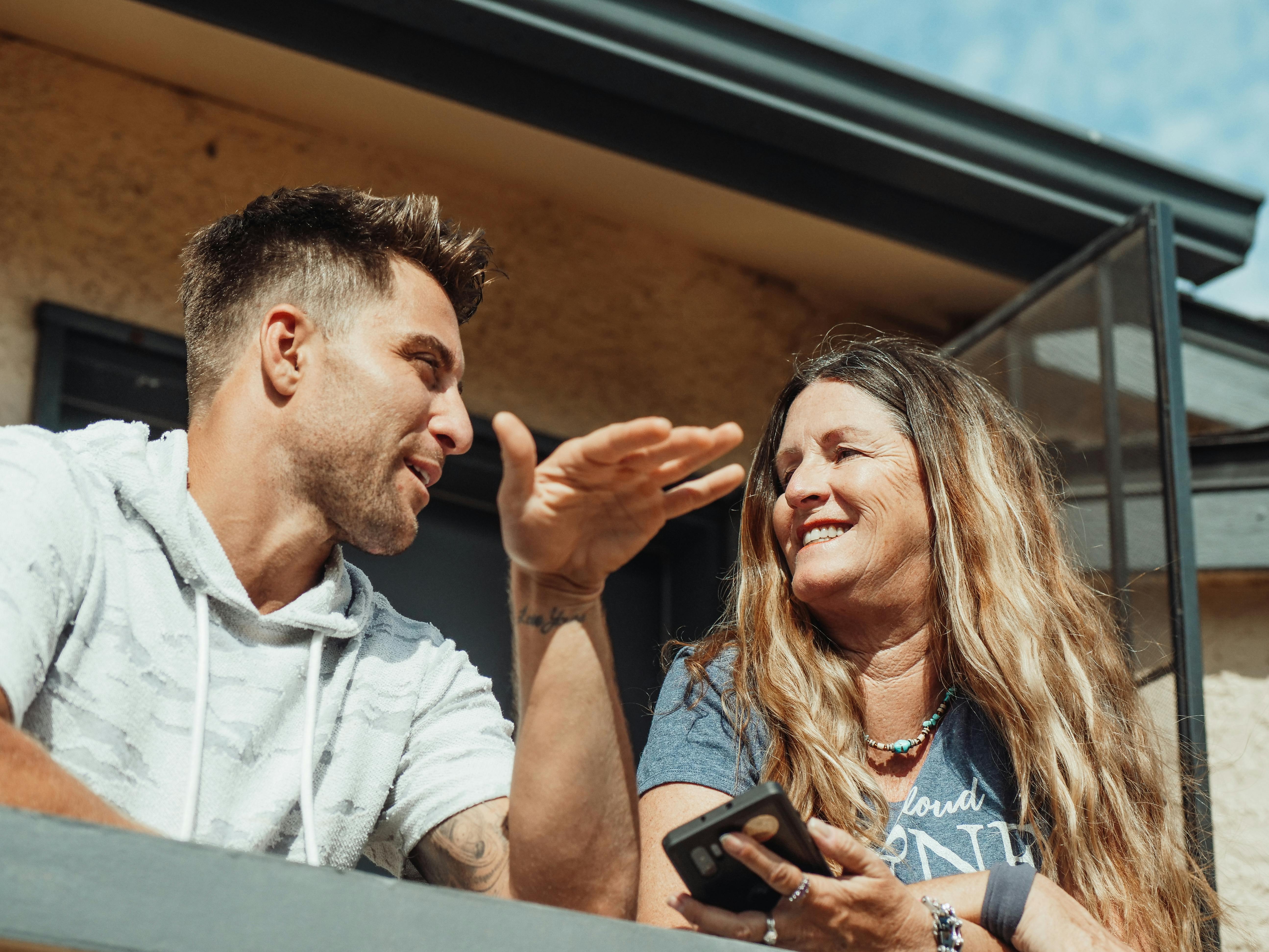 man and woman talking on a balcony