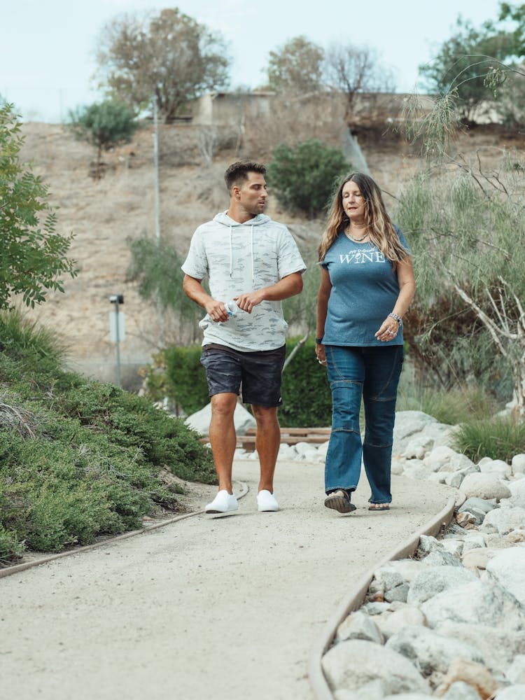 Man And Woman Walking On The Pathway 