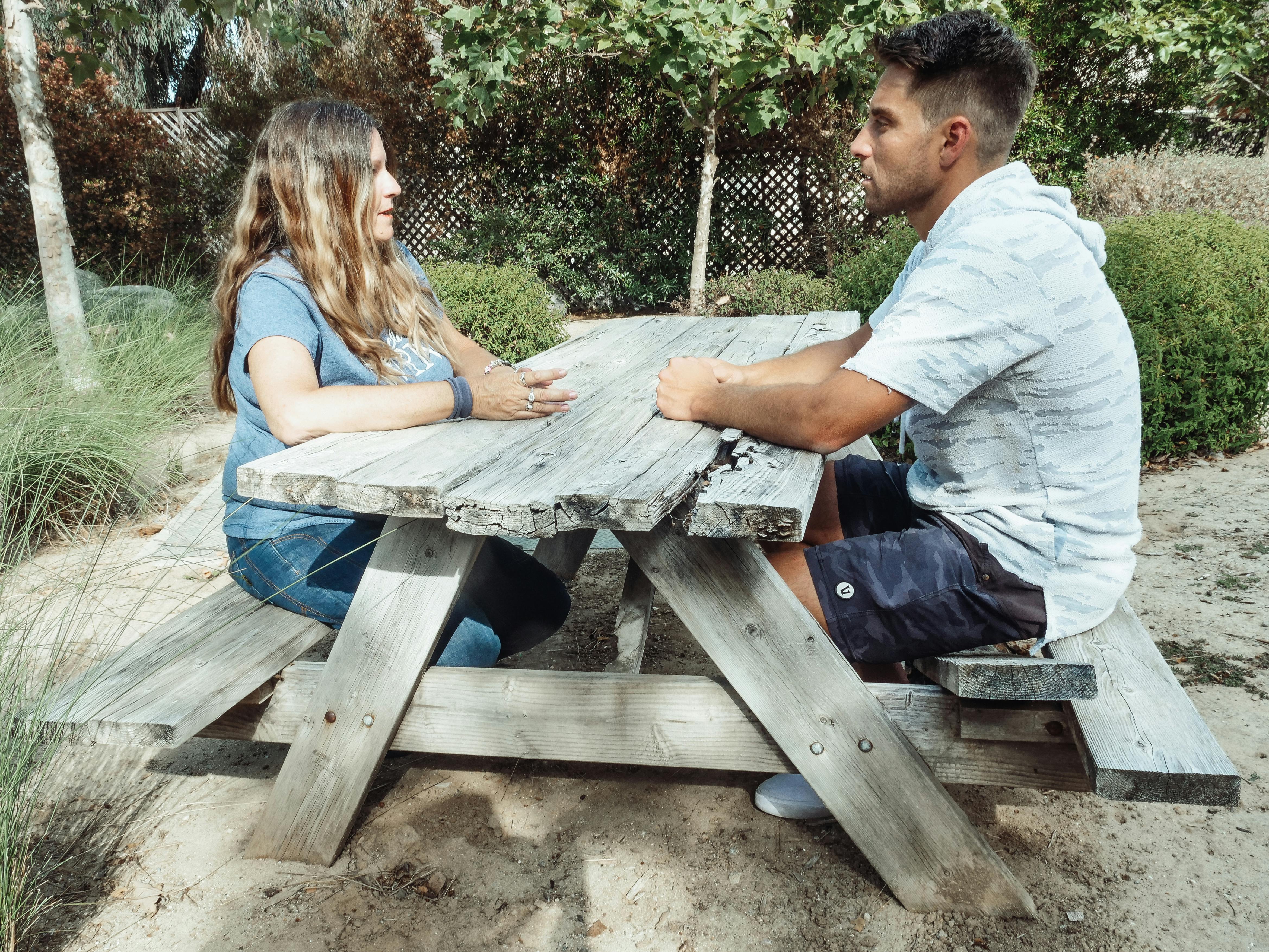 Man and Woman Sitting on a Picnic Table · Free Stock Photo