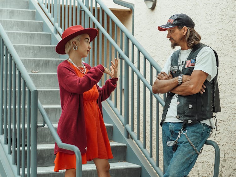 Man In Black Vest Talking To A Lady