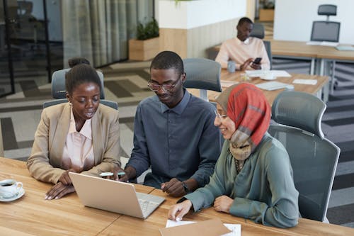 Free Colleagues Looking at a Laptop Together Stock Photo
