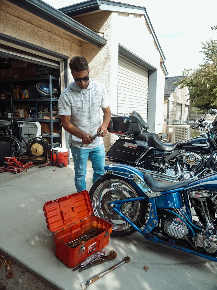 A Man Wearing Sunglasses Holding A Wrench