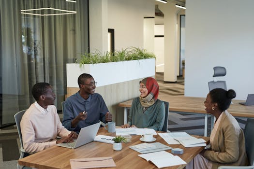 A diverse group of colleagues collaborating in a modern office setting, engaged in discussion and teamwork.
