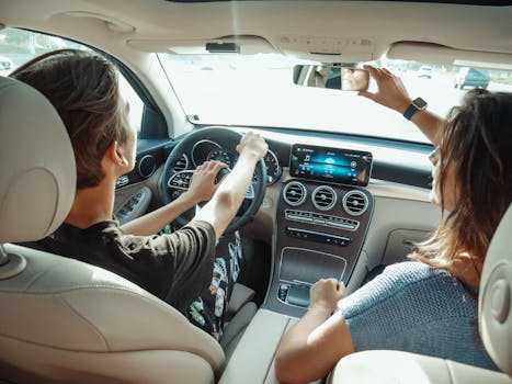 A young couple driving in a modern car, enjoying quality time together from a back view perspective.