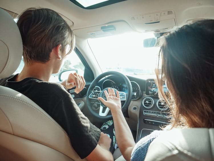 A Man In Black Shirt Driving A Car