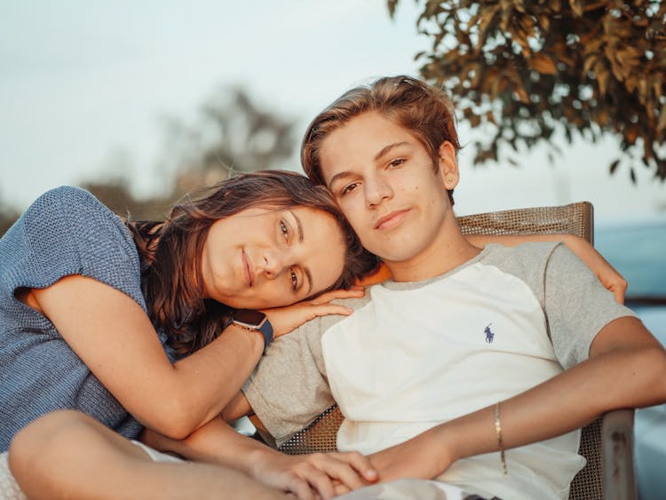 A Mother Resting Her Head On Her Son's Shoulder 