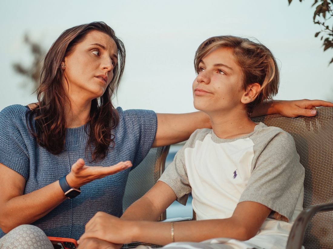 A mother and son having a conversation at home