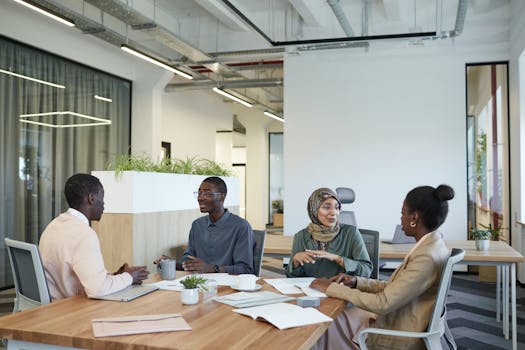 A diverse group of colleagues engaged in a meeting at a modern office workspace.