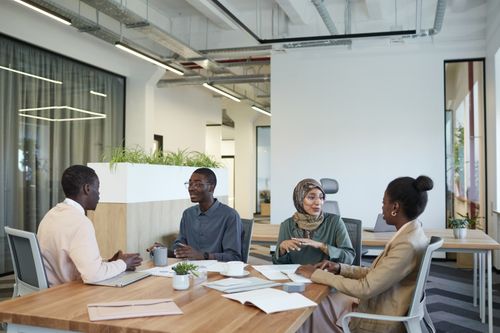 Free A diverse group of colleagues engaged in a meeting at a modern office workspace. Stock Photo