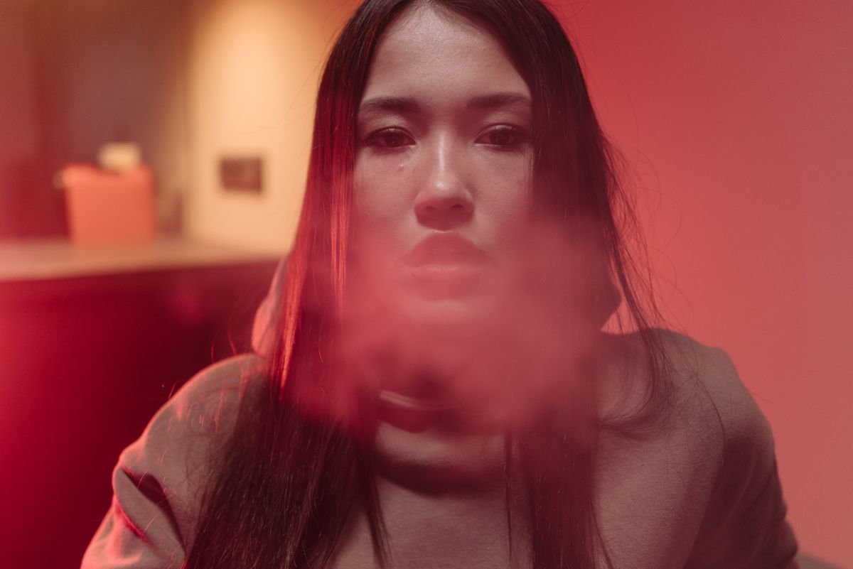 Dramatic portrait of a woman lit in a deep red ambiance
