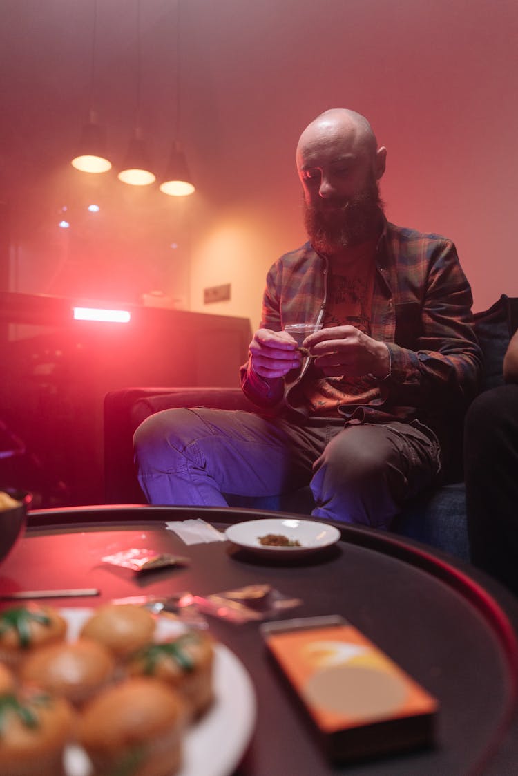 A Man Holding A Packet Of Marijuana