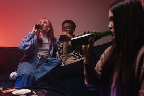 Man and Two Women Drinking Beer