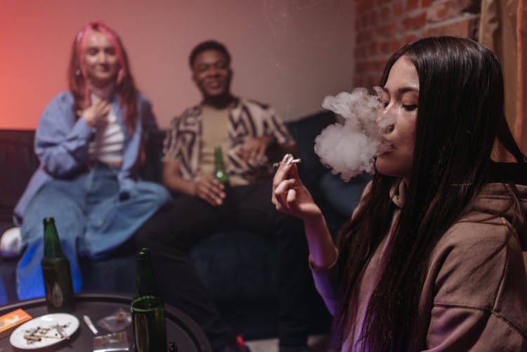 Woman In Brown Jacket Smoking Marijuana