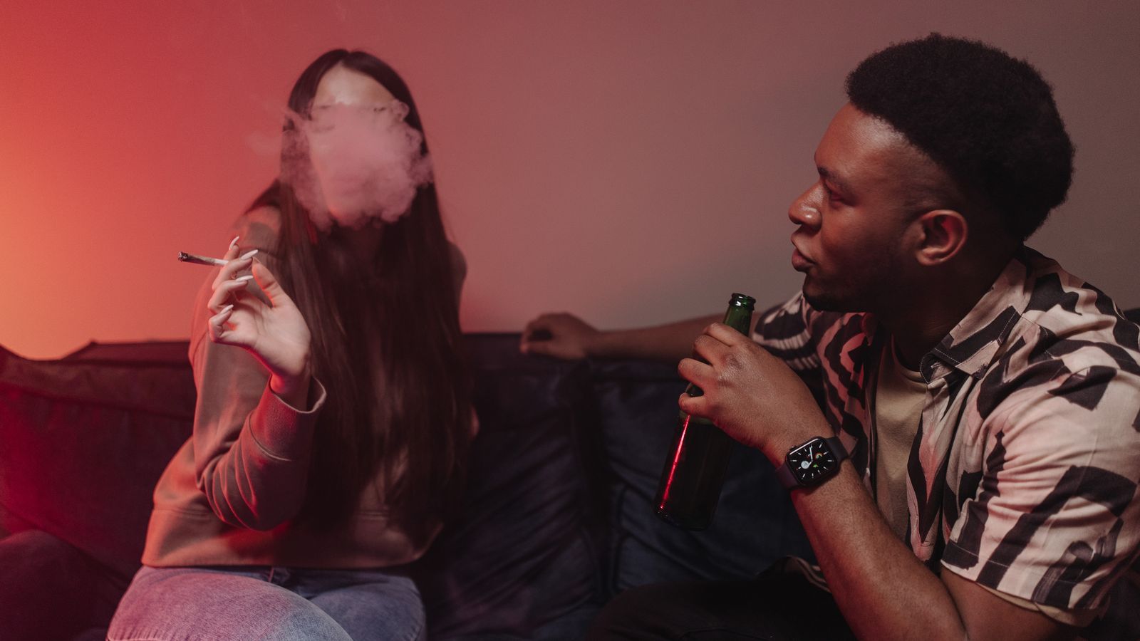 A relaxed indoor scene of friends enjoying drinks and smoking, creating a laid-back atmosphere.