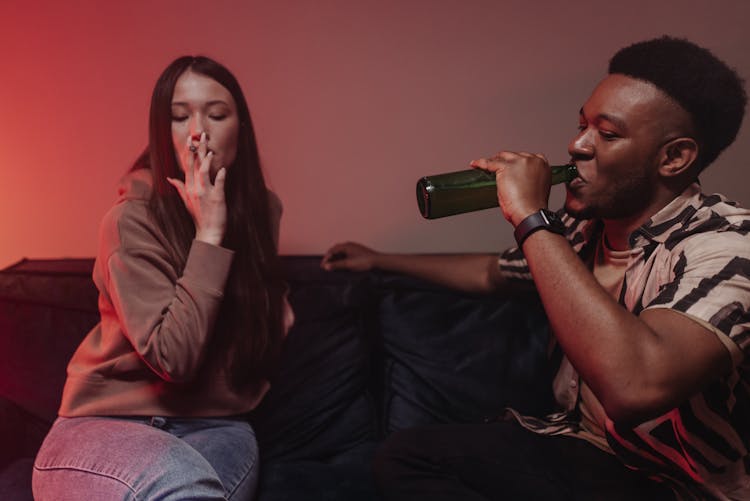 A Man Drinking Beer And A Woman Smoking