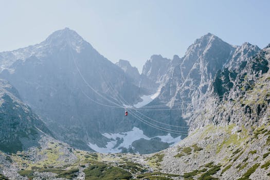 Stunning view of a red cable car traversing through the High Tatras mountains