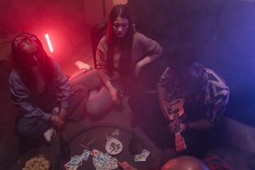 Free A cozy indoor gathering with friends playing music and games in a relaxed setting. Stock Photo