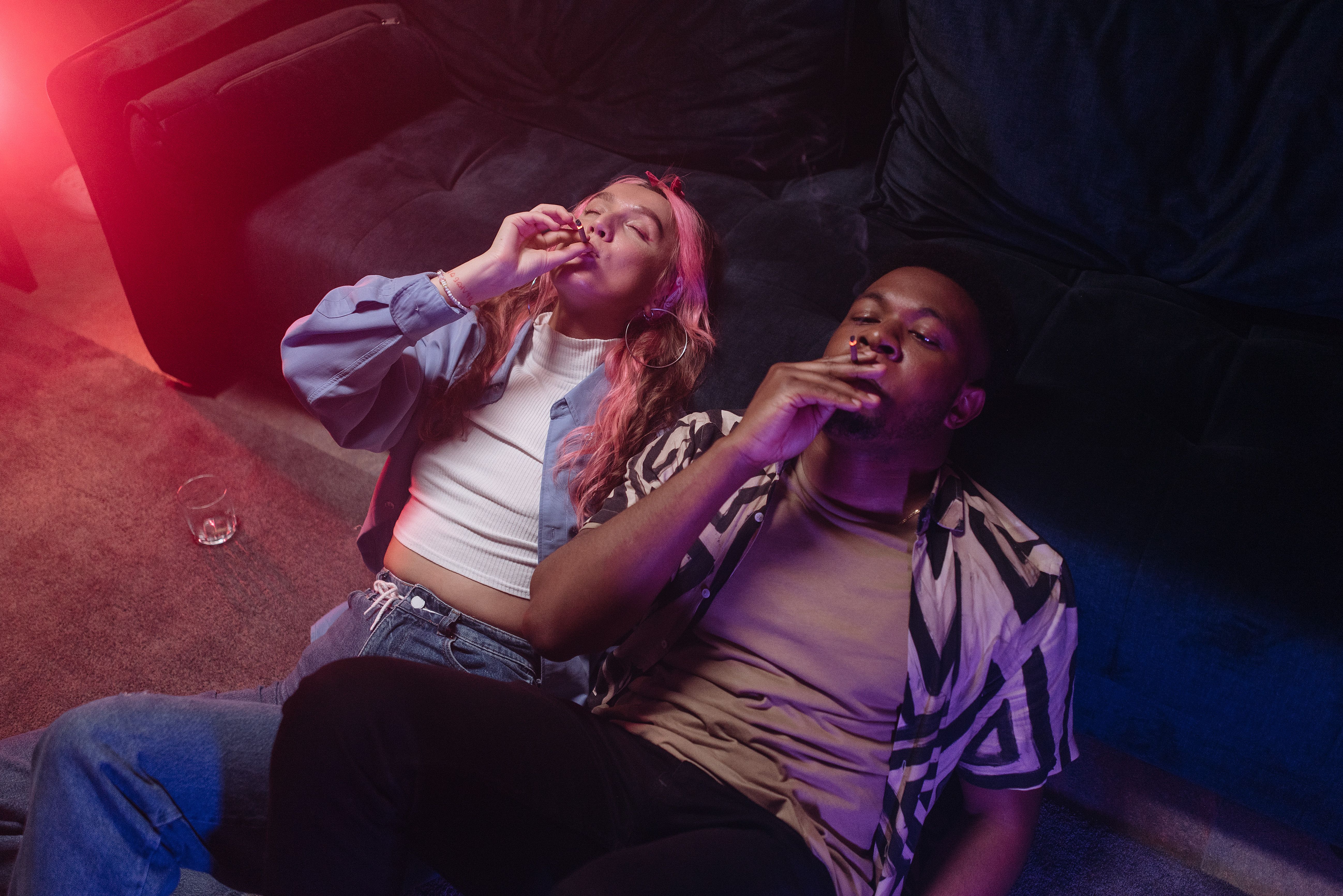 Two young adults relaxing on a sofa, enjoying a casual moment together indoors.
