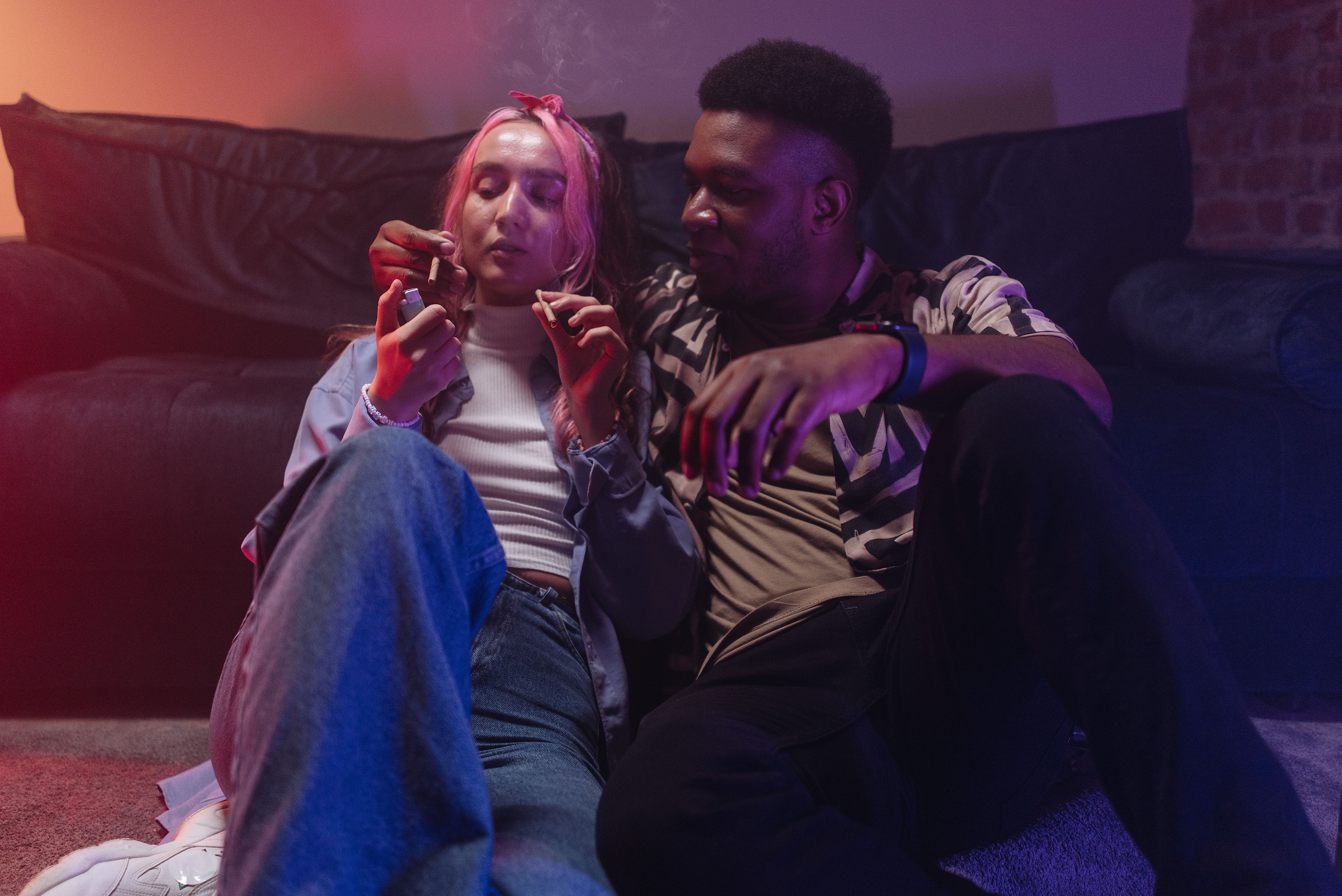 Two friends enjoying a relaxed setting at night with vibrant ambient lighting.