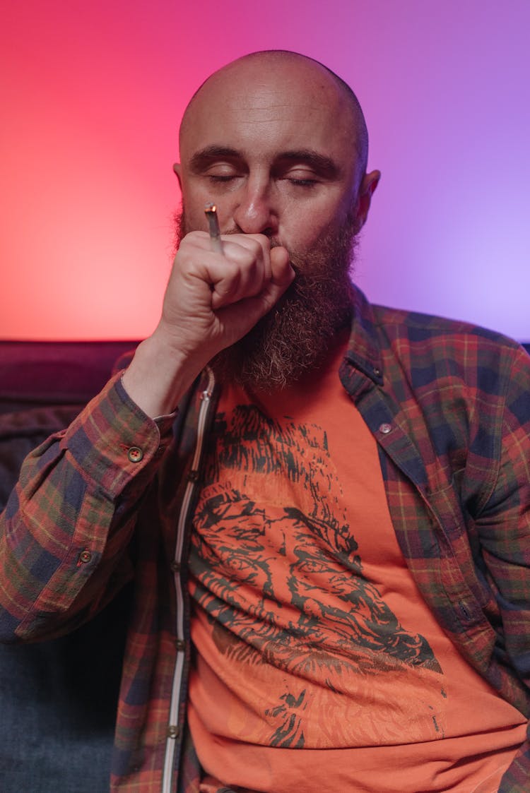 Man In Plaid Shirt Blowing Into His Hand