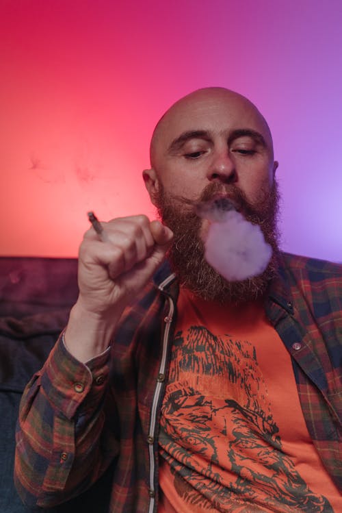 Free A Bald Man Blowing Smoke Stock Photo