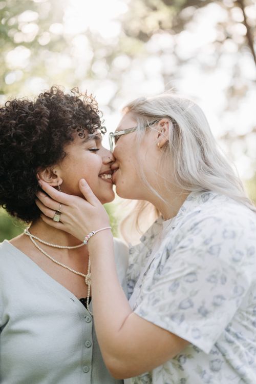 Free A loving lesbian couple shares a tender kiss outdoors, surrounded by nature. Stock Photo
