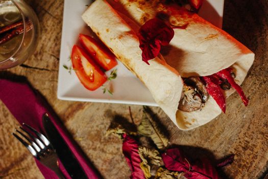 Explore a mouth-watering vegan wrap served with fresh tomato slices, crafted with vibrant ingredients and a rustic presentation., free online jigsaw puzzle on JigsawPuzzlesFreeOnline.org