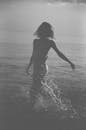 一名女子在海里泼水的黑白照片，营造出动感的剪影效果