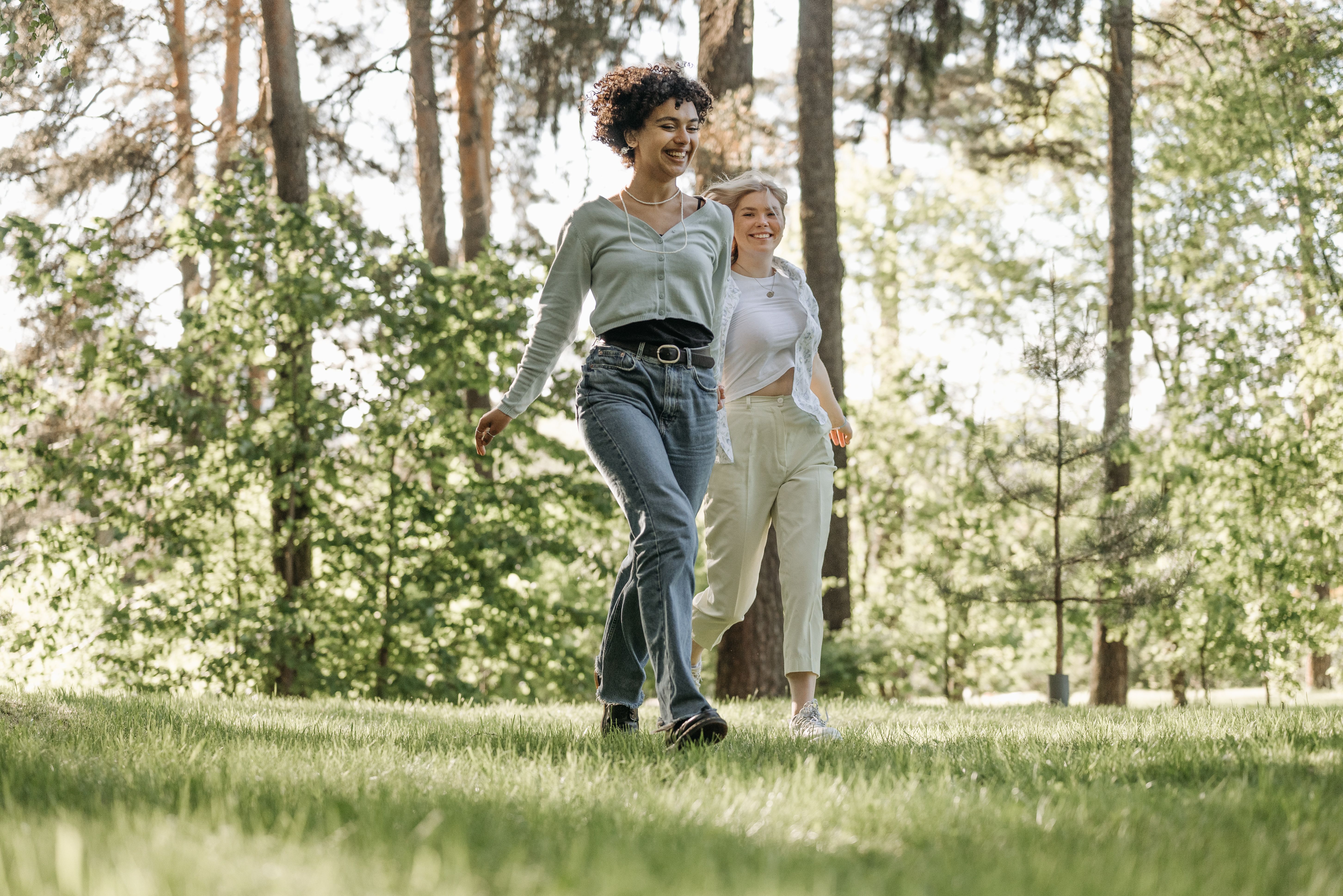Two women walking briskly together on a park path