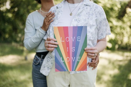 Women Holding Card with Love is Love Slogan