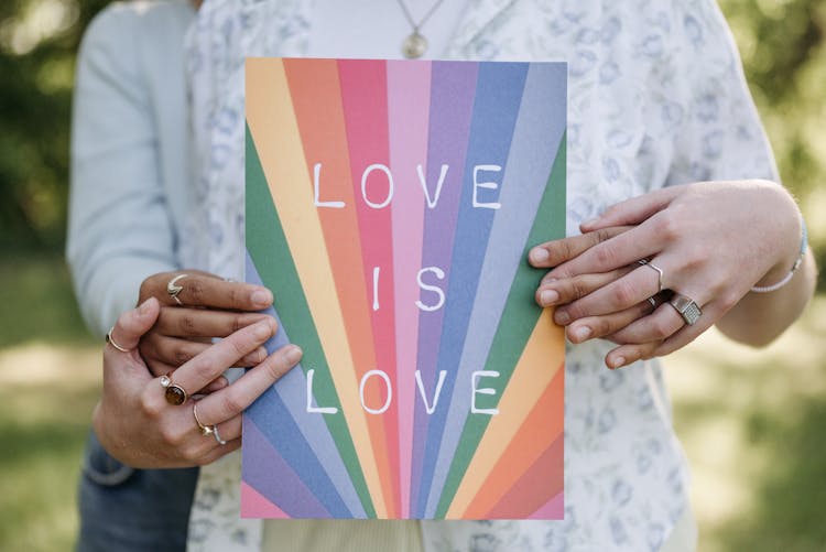 A Couple Holding A Colorful Poster