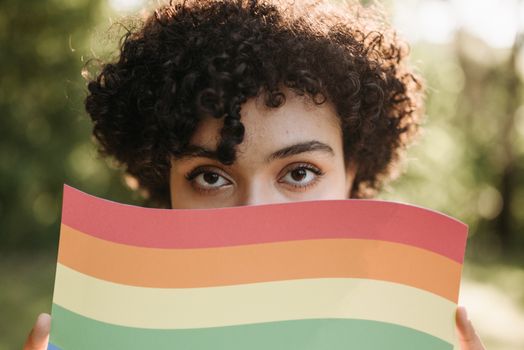 Eye-catching portrait featuring a vibrant LGBT pride flag, capturing a moment of outdoor pride.