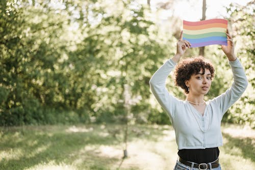 A Pretty Woman Holding a LGBT Flag