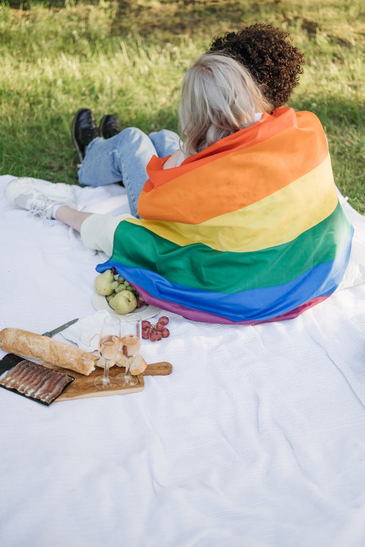 Two Women Doing Picnic With Rainbow Flag 