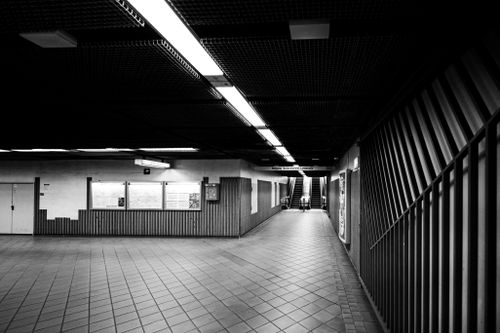 Free Black and white interior of an empty subway station featuring escalators and geometric patterns. Stock Photo