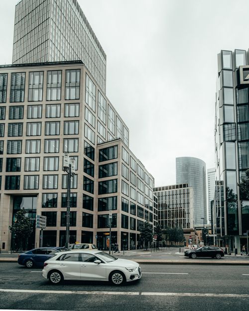 Free Modern skyscrapers lining a busy city street with cars in an urban downtown district. Stock Photo