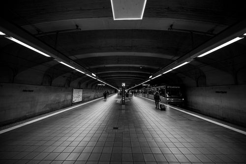 Free Dramatic black and white view of a subway station platform with commuters. Stock Photo