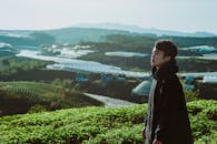 白天，一个年轻人欣赏着郁郁葱葱的温室景观