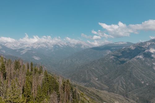 Free Scenic view of lush mountains and blue skies with fluffy clouds. Stock Photo